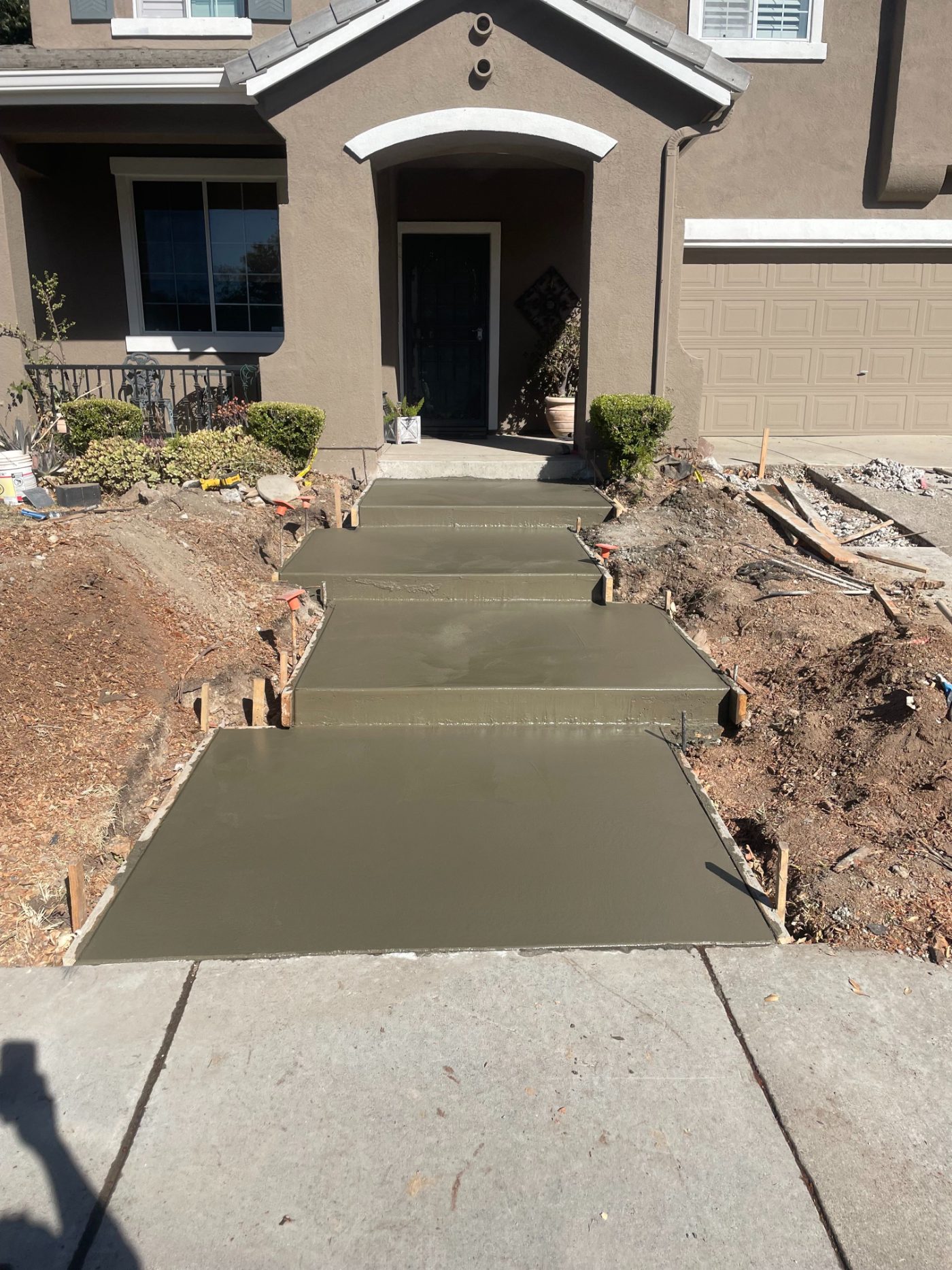 Freshly poured concrete walkway leading to a front door in Sacramento, CA